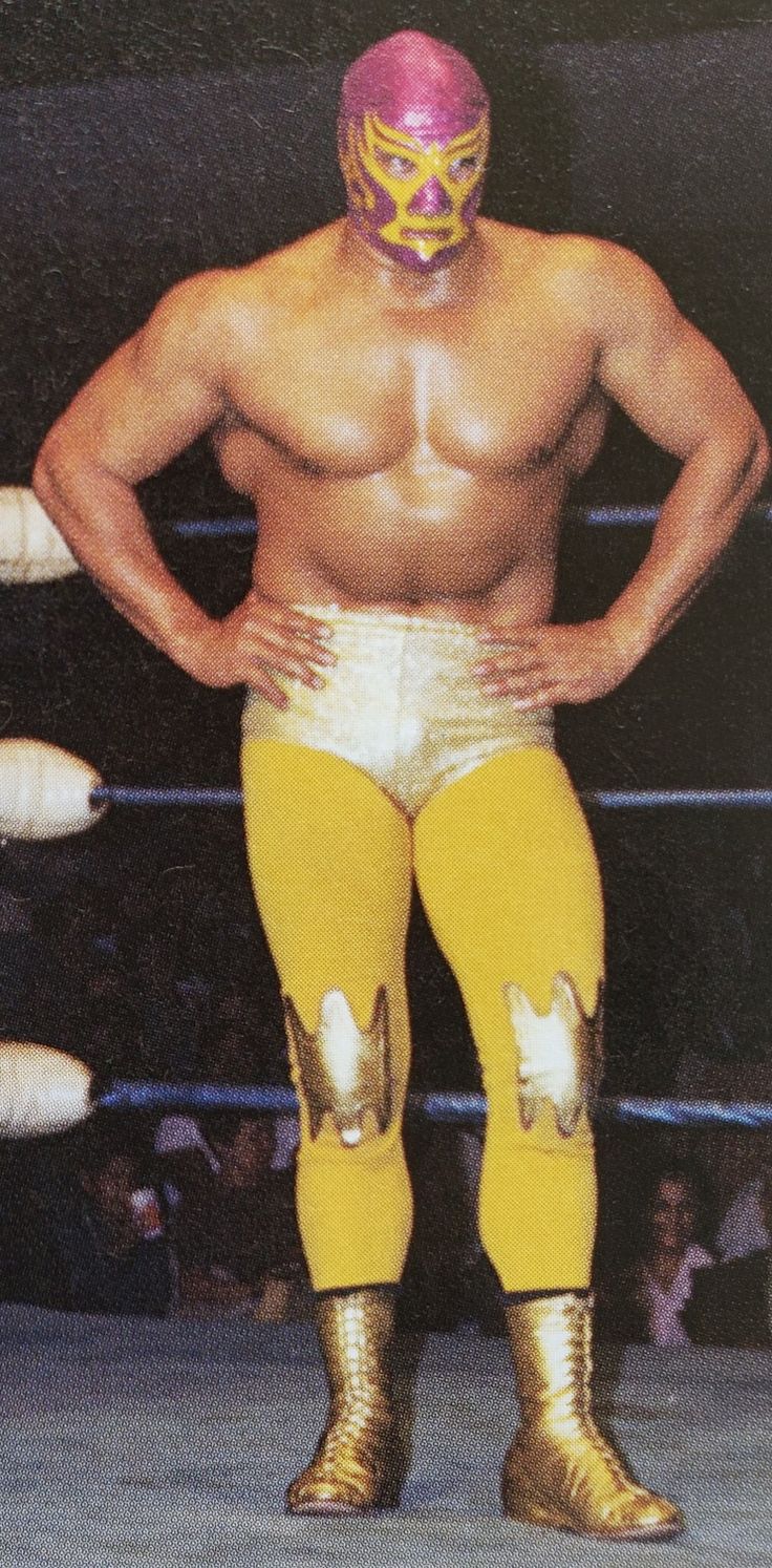 a wrestler standing in the ring with his hands on his hips