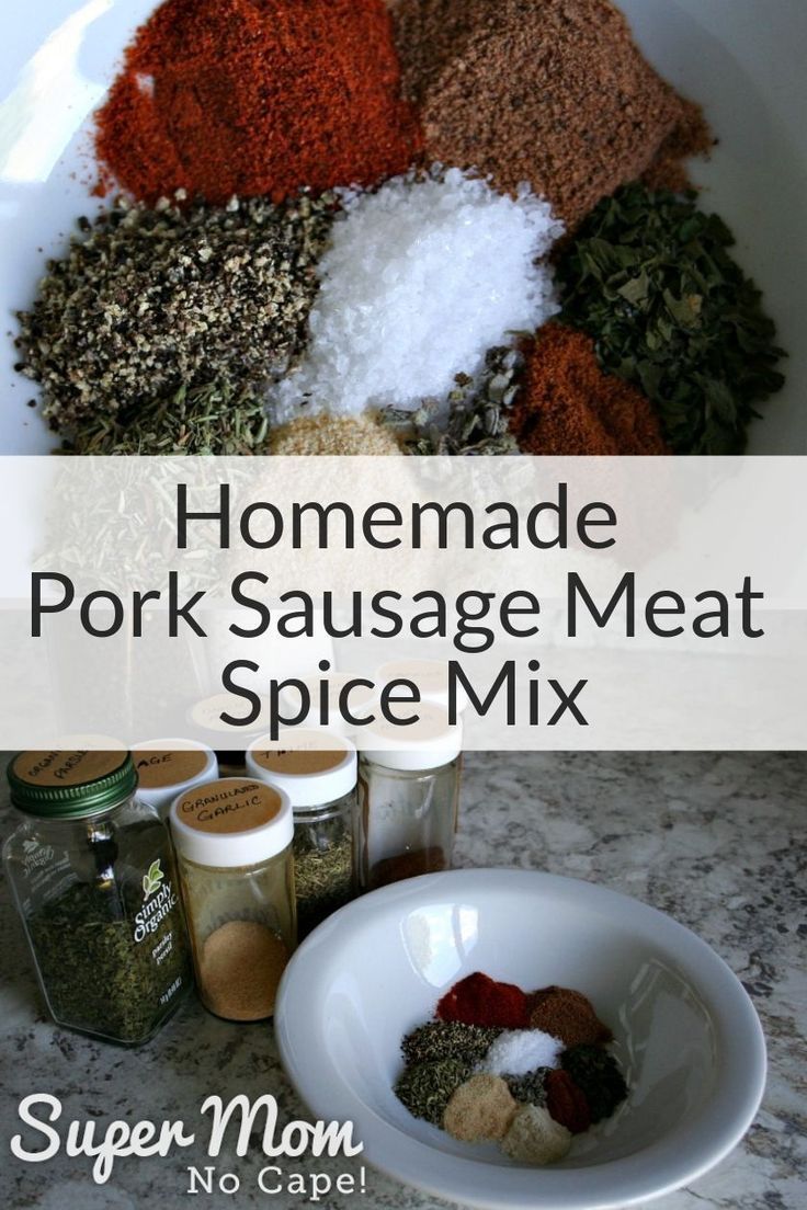 homemade pork sausage meat spice mix in a white bowl on a marble counter with spices and seasonings