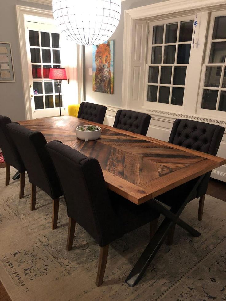 a dining room table with black chairs and a bowl of food on the centerpiece