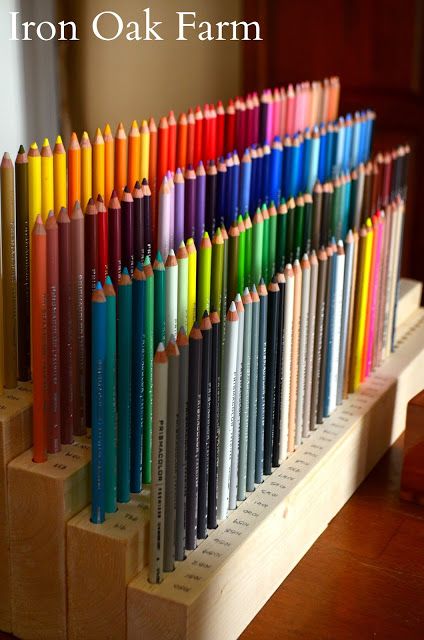 a row of colored pencils sitting on top of a wooden stand with the words iron oak farm