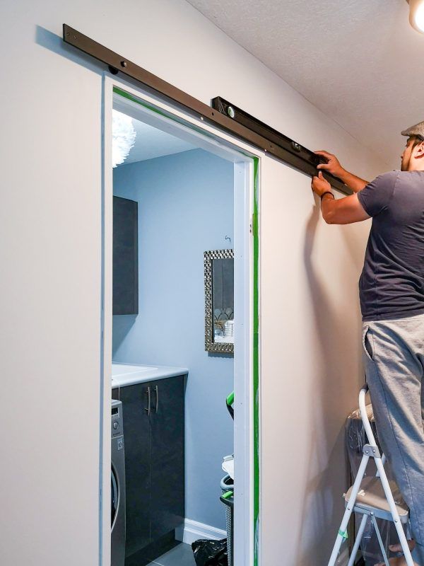 a man on a ladder painting the wall