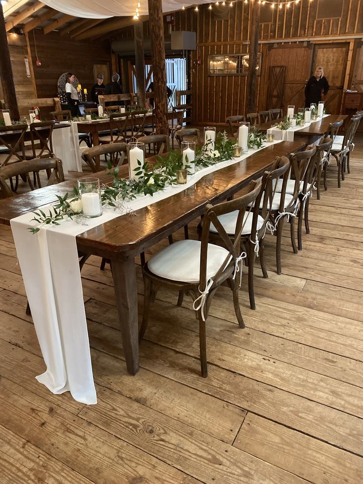 a long table with candles and greenery on it