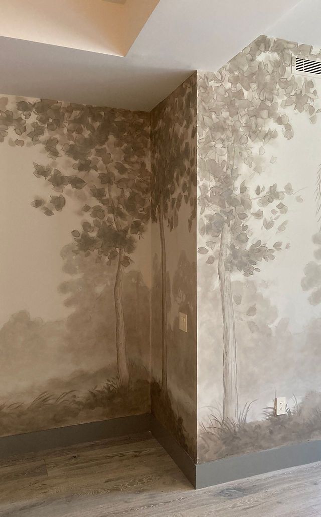 an empty room with trees painted on the wall