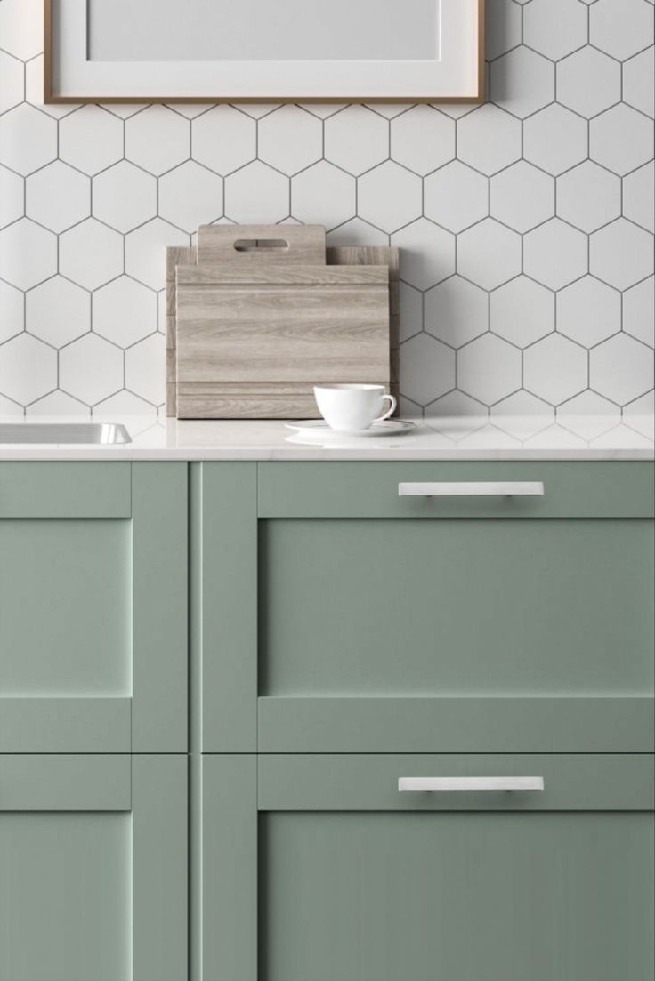 a kitchen with green cabinets and white tiled backsplash, including a wooden cutting board