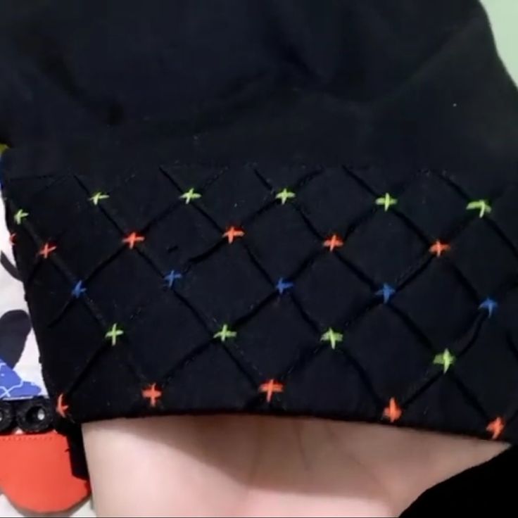 the back of a person's head wearing a black hat with multicolored stars on it