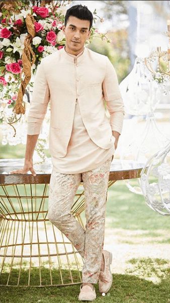 a man standing next to a table with flowers on it