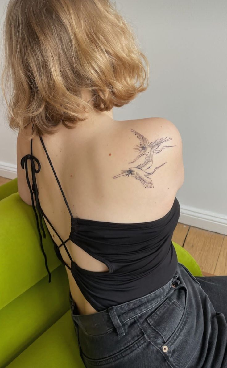 a woman with a bird tattoo on her back