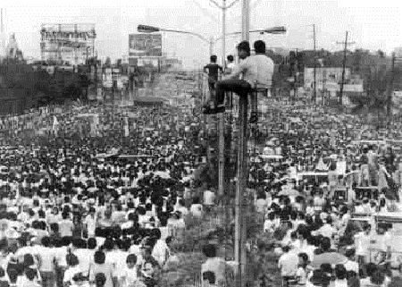 a crowd of people standing on top of a street light