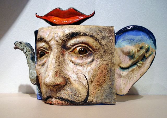 a ceramic sculpture of an old man's face with a red lips on top