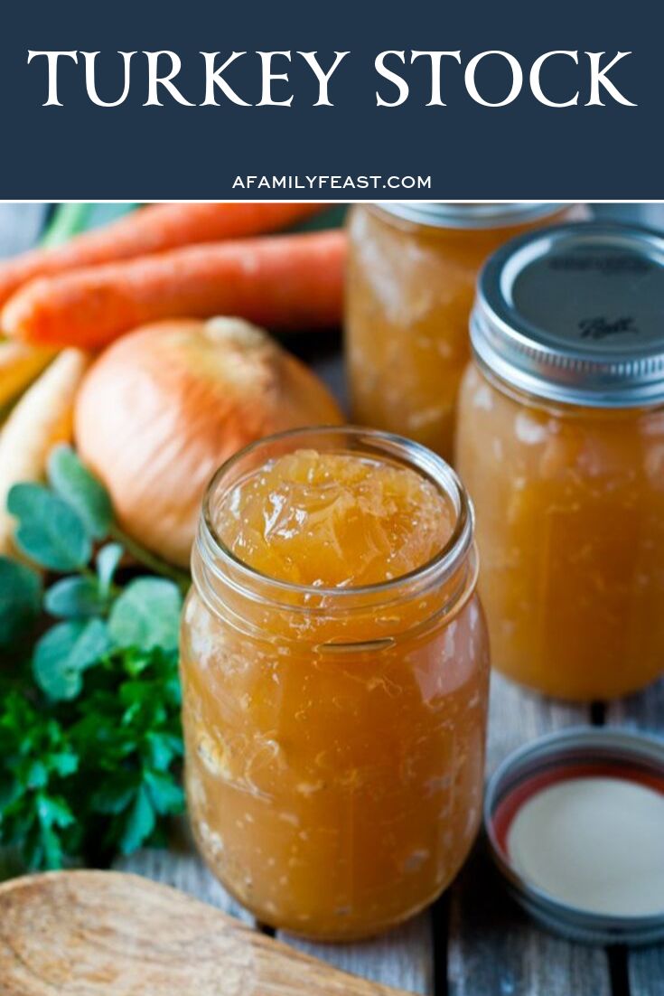 two jars filled with food sitting on top of a table next to carrots and other vegetables