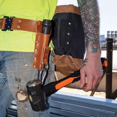 a man wearing a tool belt and carrying tools