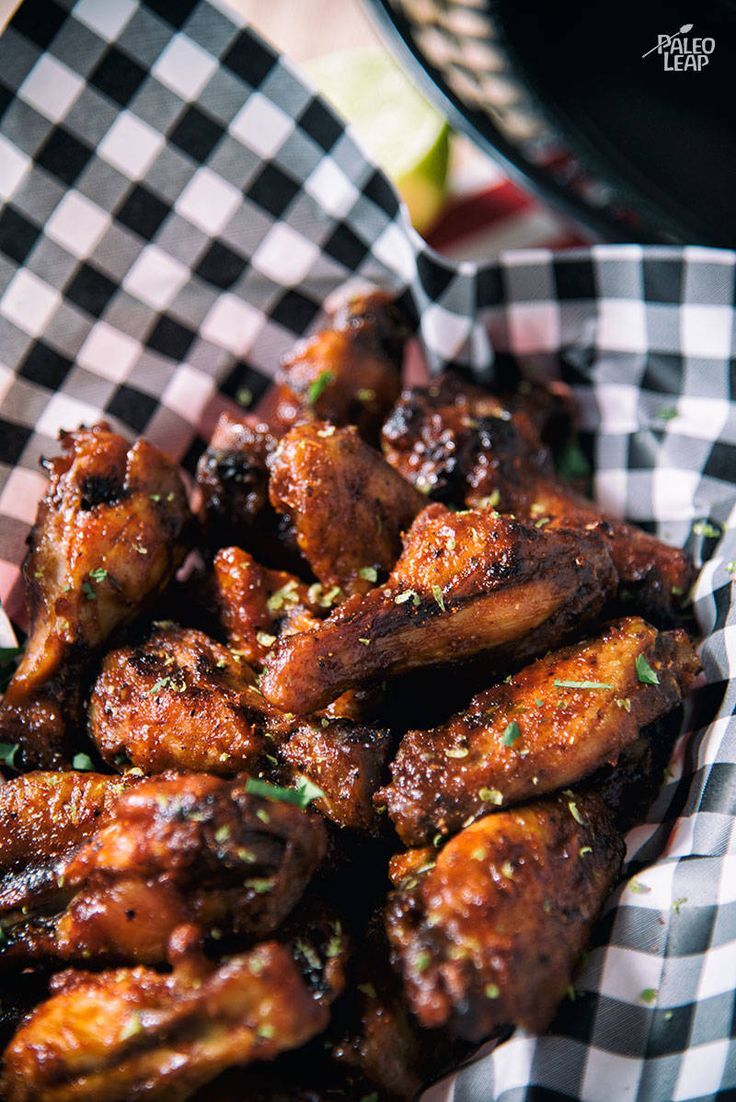 a basket filled with chicken wings covered in sauce