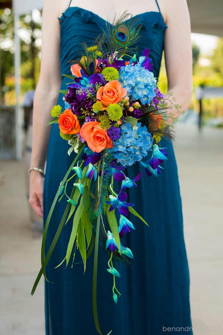 a woman in a blue dress holding a colorful bouquet