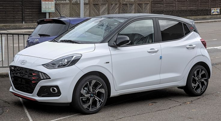 a small white car parked in a parking lot