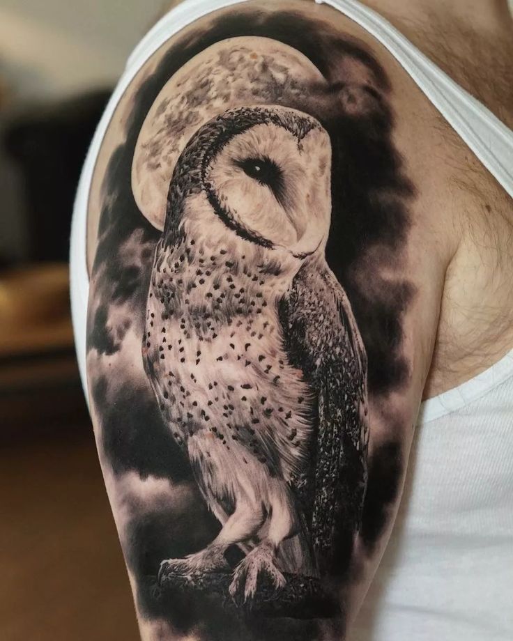 an owl tattoo on the right arm and shoulder is shown in black and white colors