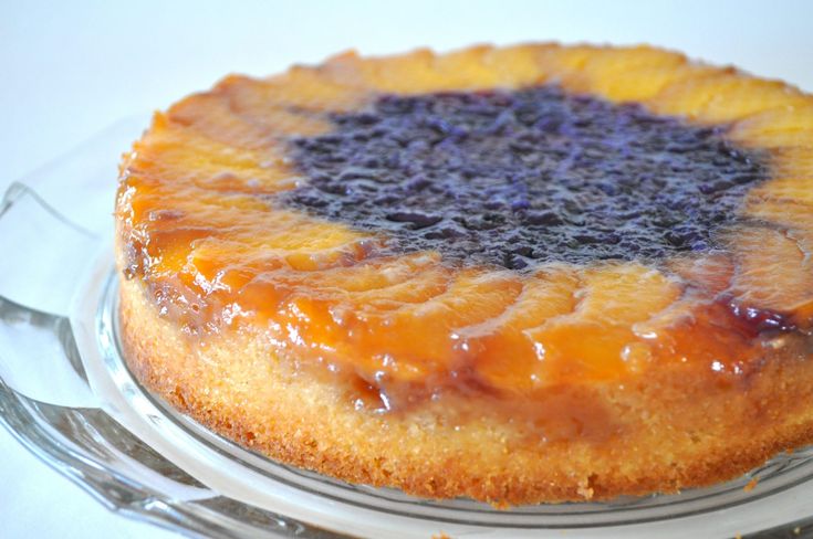 a cake sitting on top of a glass plate covered in blue and yellow icing