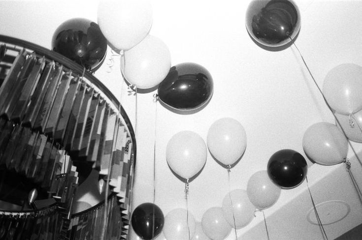 black and white balloons are hanging from the ceiling