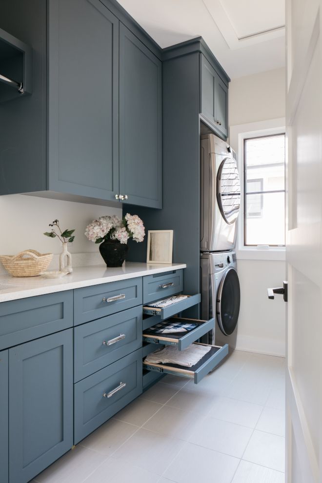 a washer and dryer in a kitchen with blue cabinets, white counter tops