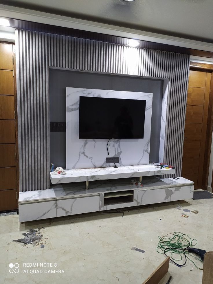 a flat screen tv sitting on top of a white entertainment center in a living room