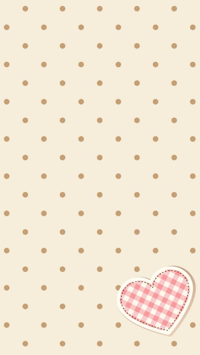 a pink heart on a beige background with polka dots