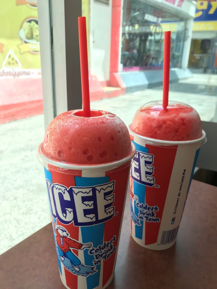 two ice cream drinks sitting next to each other on top of a table in front of a window