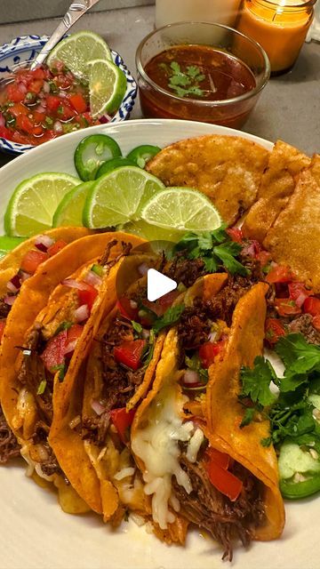 tacos and salsa on a plate with lime wedges