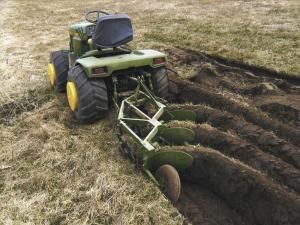 a tractor that is sitting in the dirt with it's front wheels on top