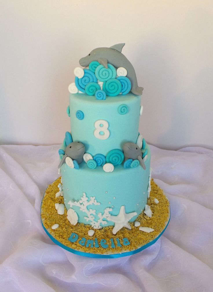 a three tiered cake decorated with blue and white decorations