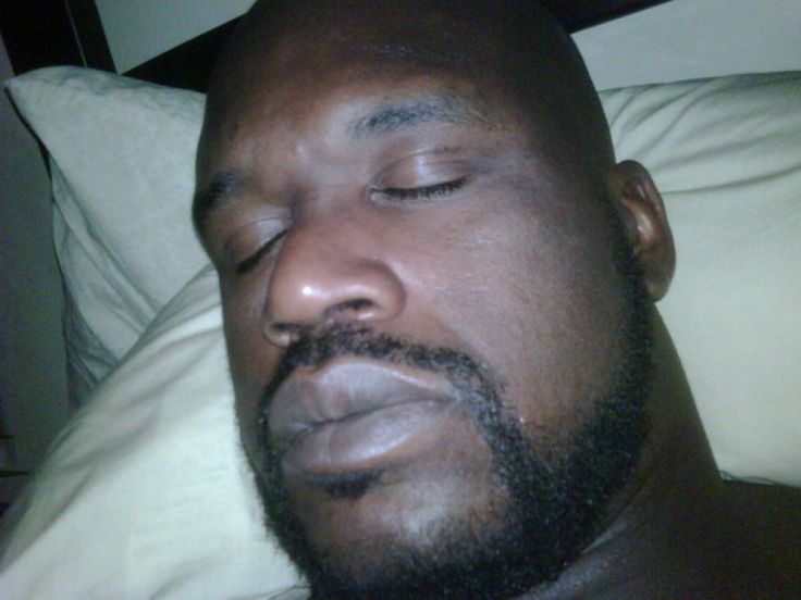 a close up of a person laying in bed with his eyes closed and head turned to the side