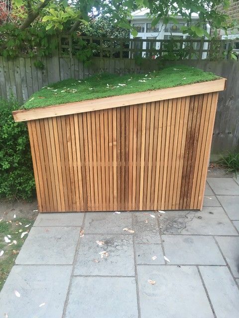 a wooden fence with grass growing on it's top and the side of it