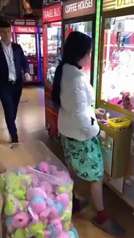 two people standing in front of a vending machine with donuts on the floor