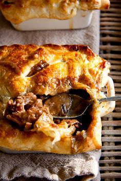 a piece of meat and cheese pie being lifted with a spoon from a casserole dish