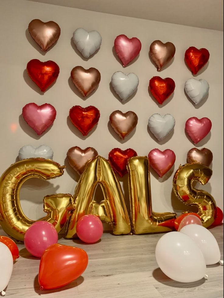 balloons and heart shaped balloons are arranged in the shape of letters that spell out love