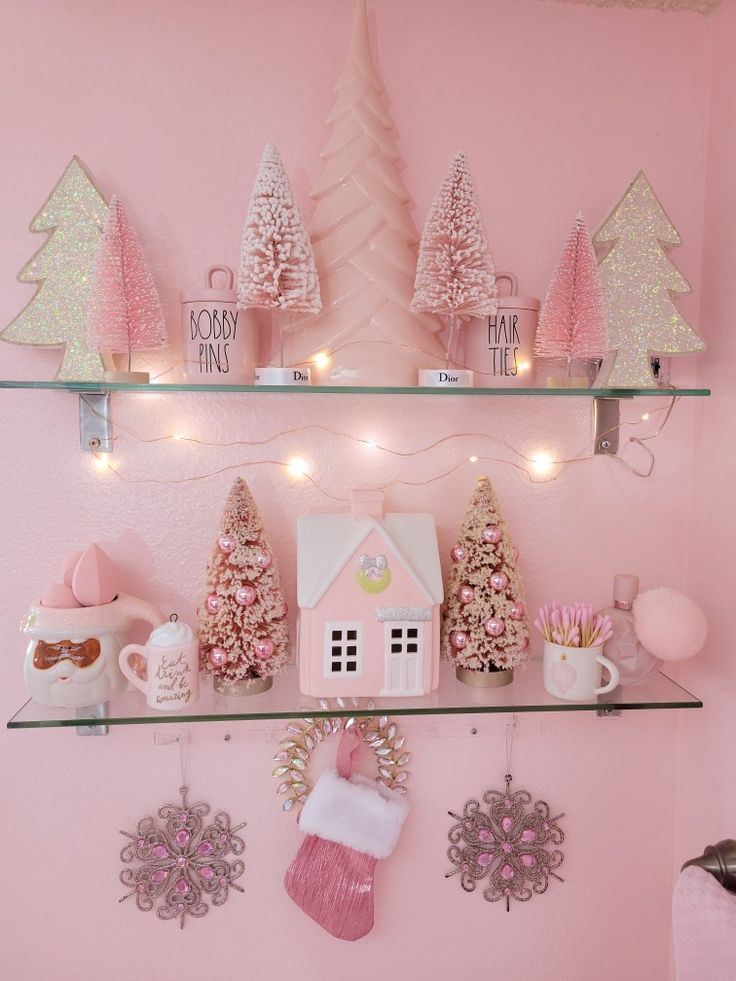 a pink room with christmas decorations on the shelves