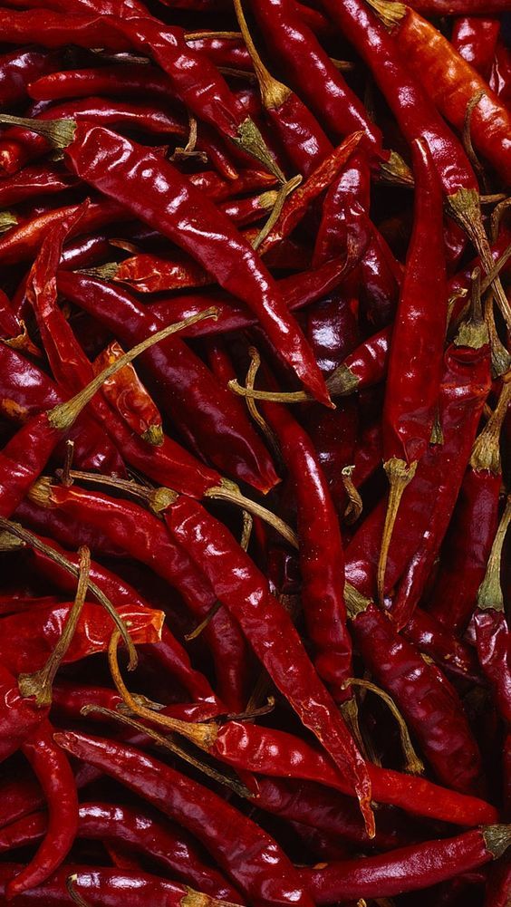 many red peppers are piled up together