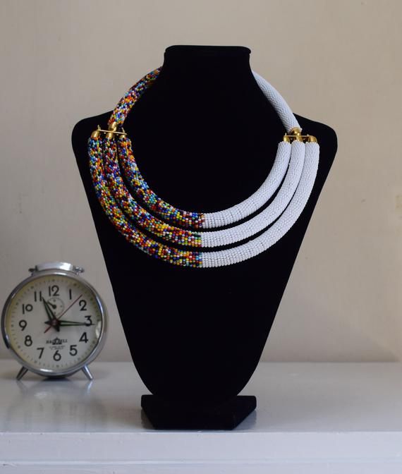 Unique African Maasai Handcrafted Beaded Necklace with an Elegant Look and Brilliant Finish.**GET FREE SHIPPING FOR ADDITIONAL ITEMS PURCHASED.Yes, Buy Multiple Items and pay shipping for 1 item only- The rest ships Free. (No Limits on the number of Multiple items). With a faster delivery time of 3 days via DHLExpress, Worldwide. Ordinary/Standard Shipping also available upon request. We Custom Make to Suit Your Taste.Available In All Colors and Sizes.For wholesale please chat me up for discount Bohemian White Jewelry With Black Beads, Unique White Choker Necklace, Traditional White Necklace With Colorful Beads, Traditional White Jewelry With Tiny Beads, White Bohemian Necklace With Black Beads, Unique White Jewelry With Black Beads, Traditional White Adjustable Beaded Necklace, Traditional White Beaded Necklaces With Adjustable Fit, Traditional White Choker With Round Beads