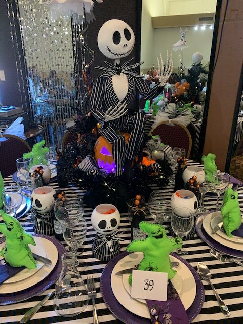 a table set for halloween dinner with skeleton decorations