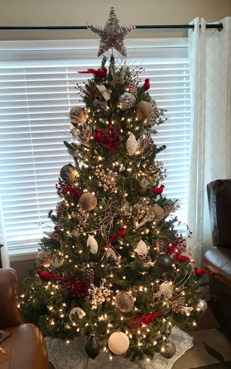 a decorated christmas tree in front of a window