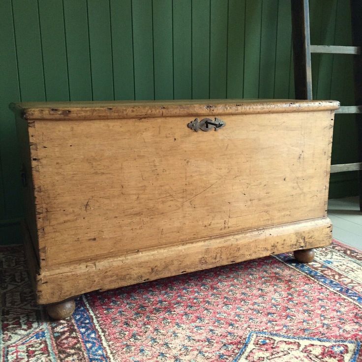 an old wooden chest sitting on top of a rug