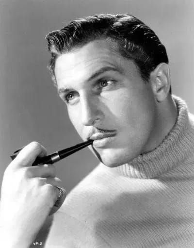 a man with a pipe in his mouth is looking at the camera while wearing a sweater