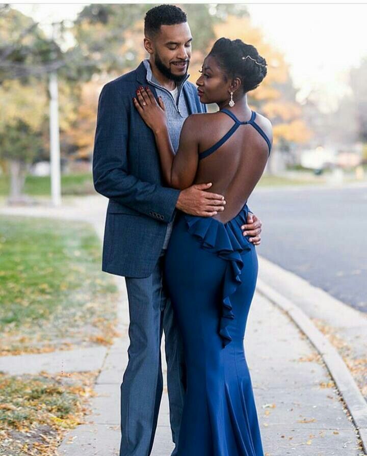 a man and woman standing next to each other on a sidewalk