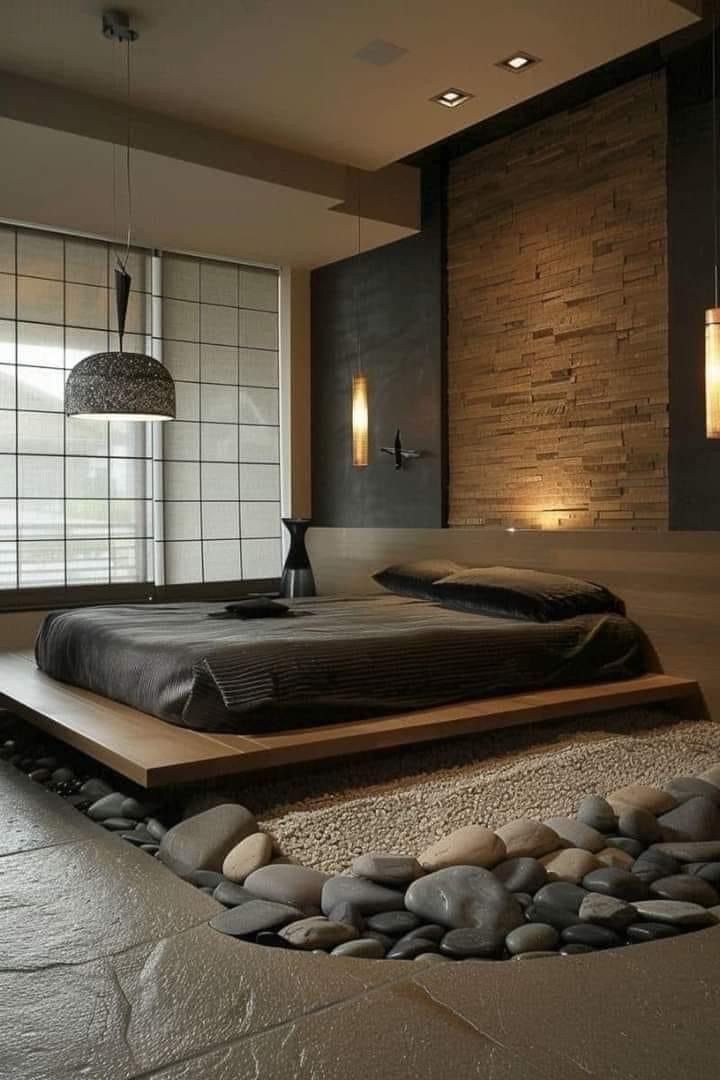 a large bed sitting in the middle of a bedroom next to a stone wall and floor