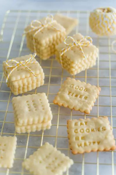 some cookies are on a cooling rack with words written on them and tied in twine