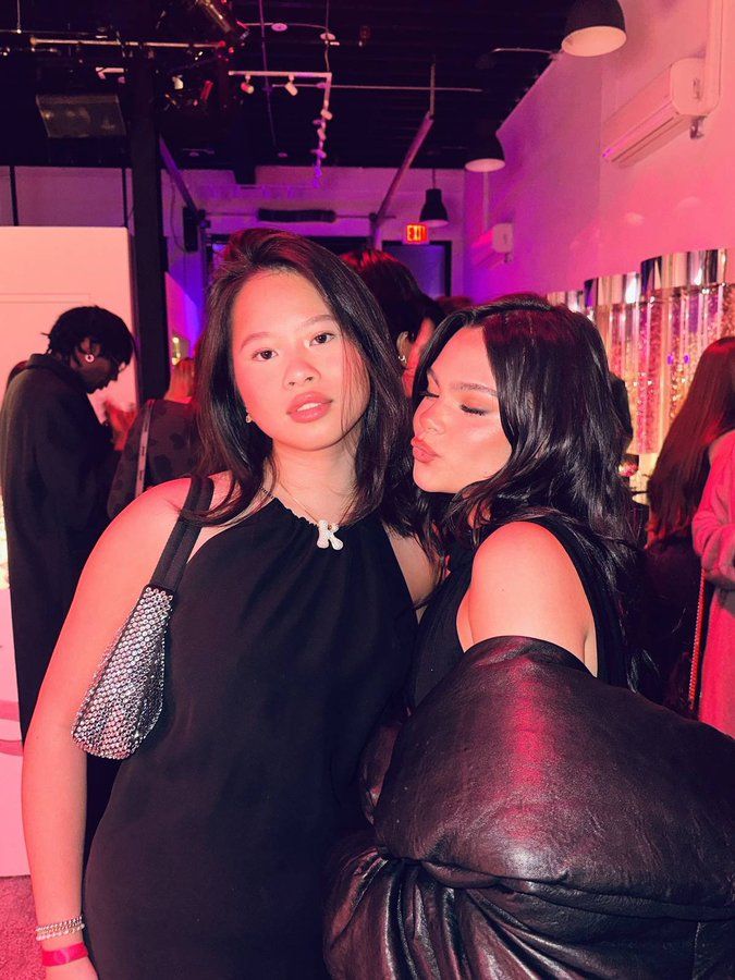 two women standing next to each other at a party