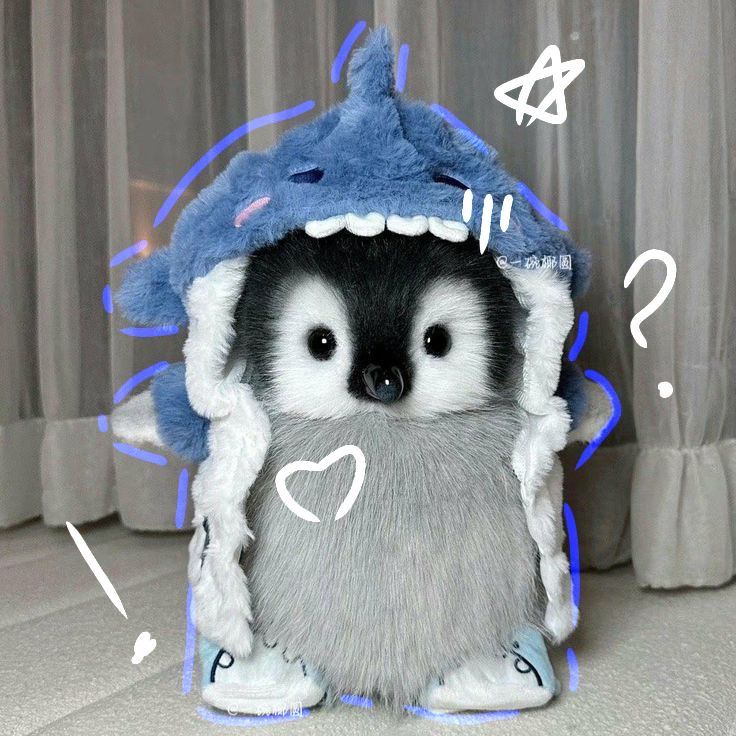 a stuffed animal that is wearing a blue shark hoodie with white writing on it