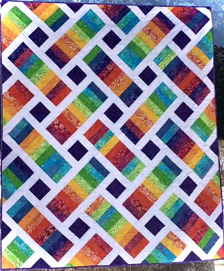 a colorful quilt is displayed on the ground