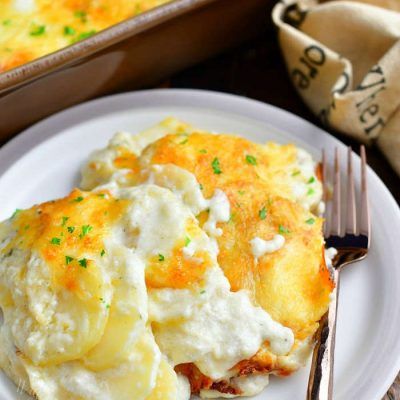 a white plate topped with mashed potatoes next to a fork and casserole