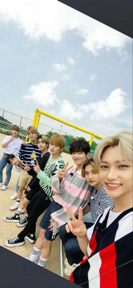 a group of young men standing next to each other on a baseball field with the caption stray kids