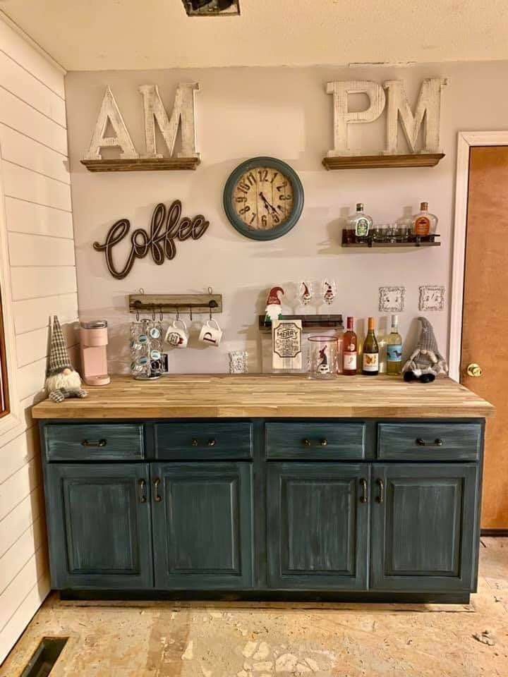 a kitchen with blue cabinets and an old clock mounted on the wall above it's counter