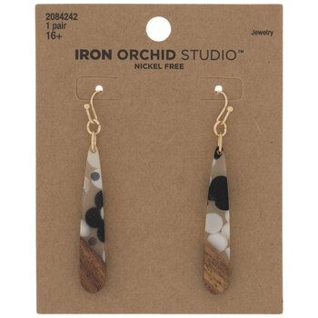 the iron orchid studio earrings are made from wood and glass with black dots on them